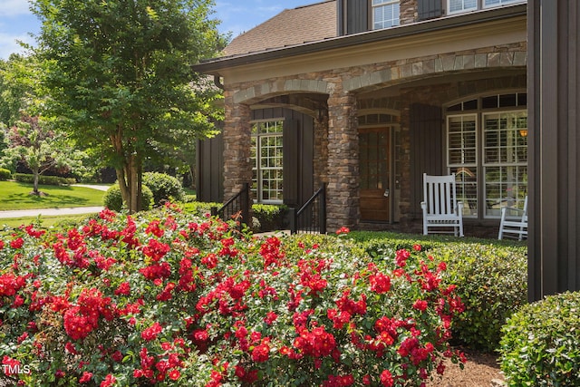 property entrance featuring a porch and stone siding