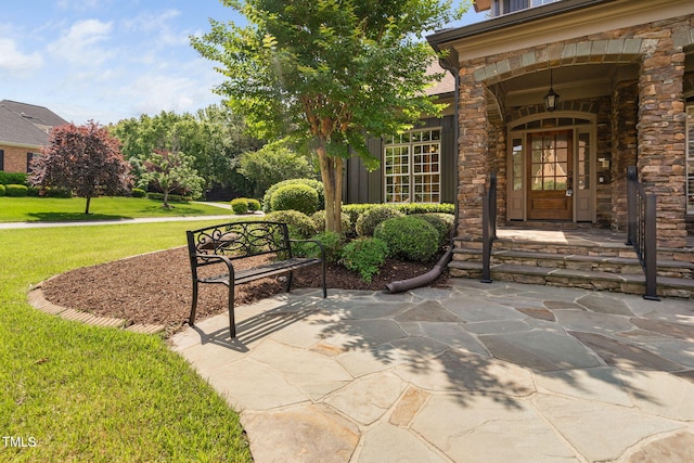 doorway to property with a yard and stone siding