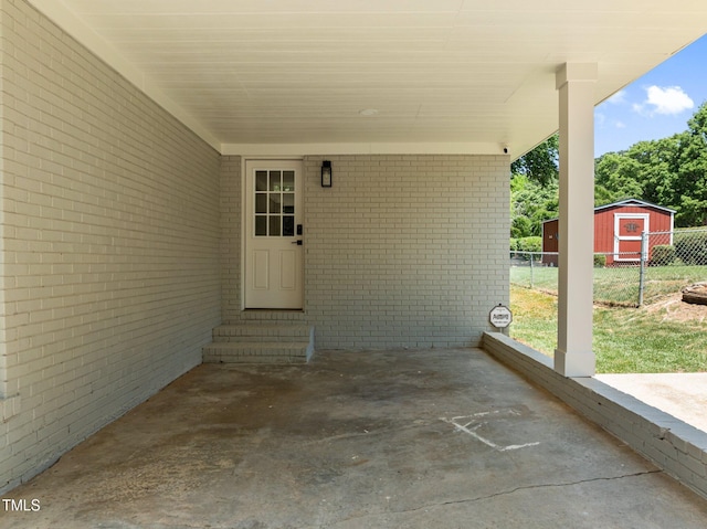 5208 Melbourne Rd, Raleigh, NC 27606 - view of patio / terrace featuring entry steps, fence, a storage shed, an attached carport, and an outbuilding
