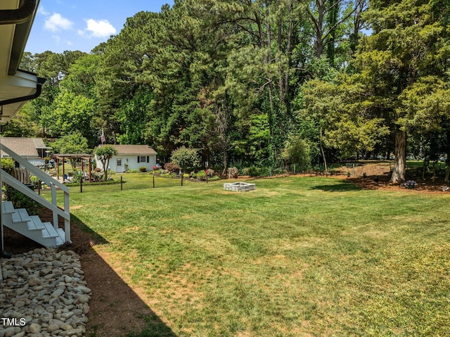 5208 Melbourne Rd, Raleigh, NC 27606 - view of grassy yard featuring an outdoor fire pit and stairs