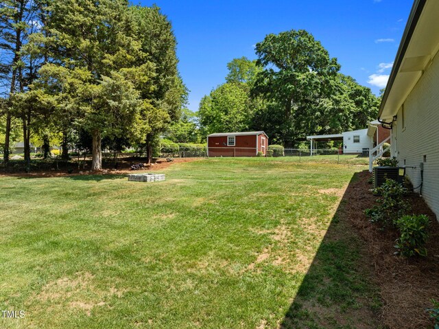 5208 Melbourne Rd, Raleigh, NC 27606 - view of yard featuring central air condition unit and an outbuilding