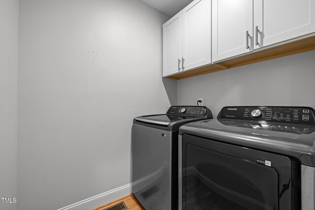 5208 Melbourne Rd, Raleigh, NC 27606 - laundry room with cabinet space, washer and dryer, baseboards, and wood finished floors