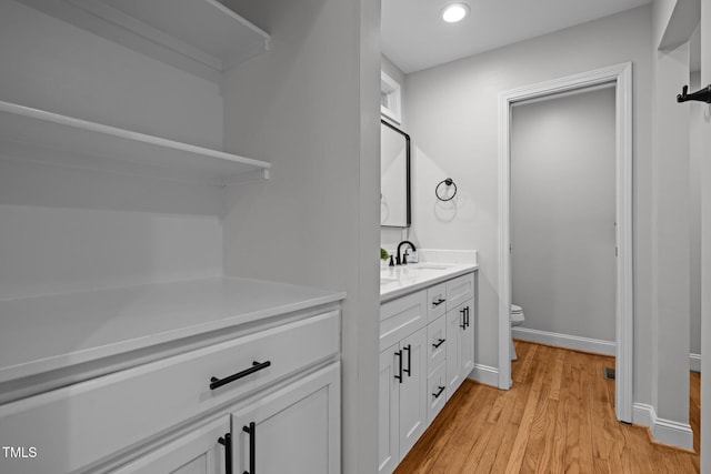 5208 Melbourne Rd, Raleigh, NC 27606 - bathroom with toilet, wood finished floors, vanity, recessed lighting, and baseboards