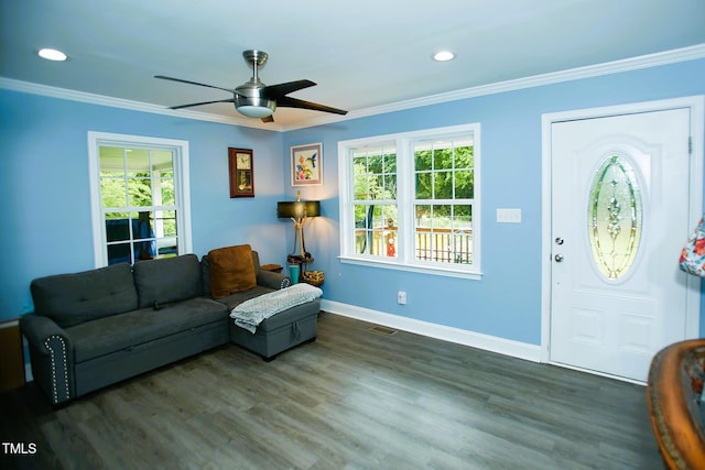 living room with healthy amount of natural light, ornamental molding, a ceiling fan, baseboards, and wood finished floors