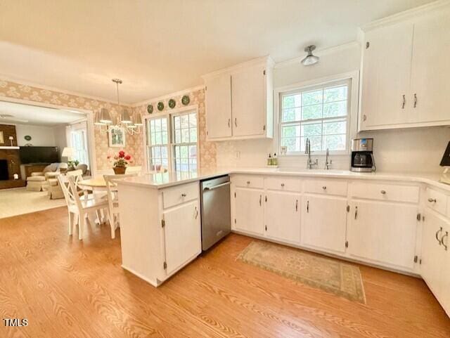 kitchen with dishwasher, a sink, light wood-style flooring, a peninsula, and white cabinets
