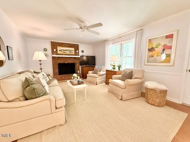 living area with ceiling fan and a fireplace