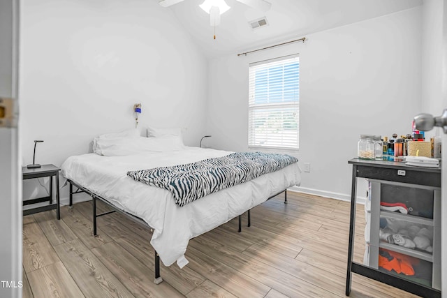 bedroom featuring wood finished floors, lofted ceiling, a ceiling fan, and baseboards