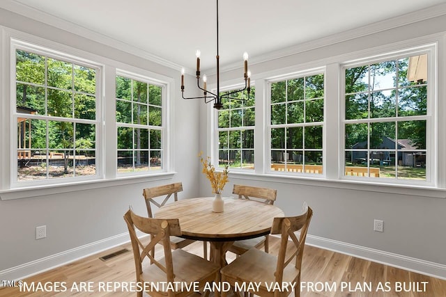 1412 Sagamore Dr, Louisburg, NC 27549 - dining room featuring an inviting chandelier, light wood-type flooring, visible vents, baseboards, and ornamental molding