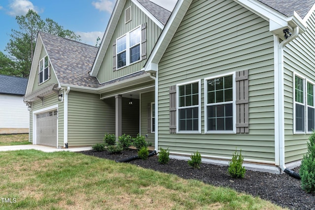 1412 Sagamore Dr, Louisburg, NC 27549 - view of front facade featuring board and batten siding, a shingled roof, a front lawn, and an attached garage