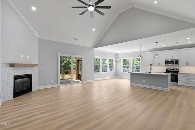 1412 Sagamore Dr, Louisburg, NC 27549 - unfurnished living room with recessed lighting, a ceiling fan, high vaulted ceiling, a glass covered fireplace, and light wood-type flooring