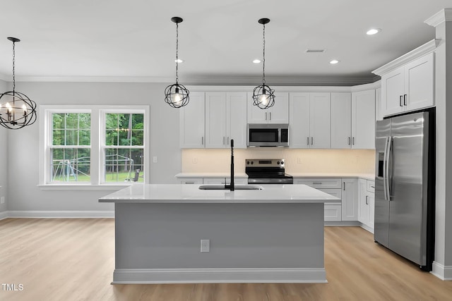 1412 Sagamore Dr, Louisburg, NC 27549 - kitchen featuring appliances with stainless steel finishes, ornamental molding, light wood-type flooring, light countertops, and a kitchen island with sink