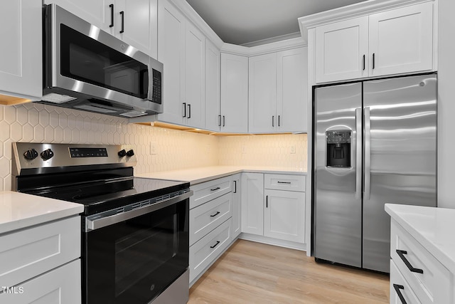 1412 Sagamore Dr, Louisburg, NC 27549 - kitchen featuring appliances with stainless steel finishes, light countertops, decorative backsplash, white cabinetry, and light wood-type flooring