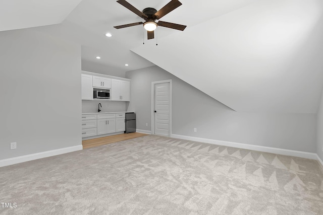 1412 Sagamore Dr, Louisburg, NC 27549 - unfurnished living room featuring vaulted ceiling, light carpet, a ceiling fan, recessed lighting, and bar area