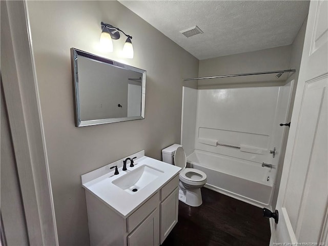 5472 Robmont Dr, Fayetteville, NC 28306 - full bath featuring toilet, wood finished floors, vanity, a textured ceiling, and visible vents