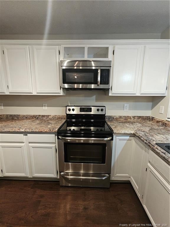 5472 Robmont Dr, Fayetteville, NC 28306 - kitchen featuring stainless steel appliances, dark wood-style floors, and white cabinets