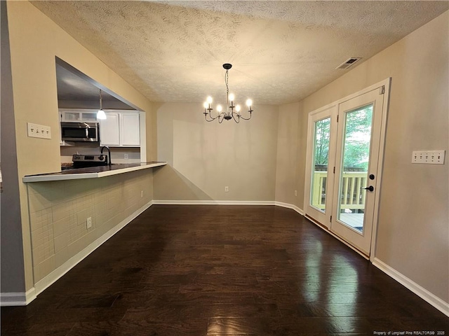 5472 Robmont Dr, Fayetteville, NC 28306 - unfurnished dining area with dark wood-style flooring, a textured ceiling, visible vents, and a chandelier