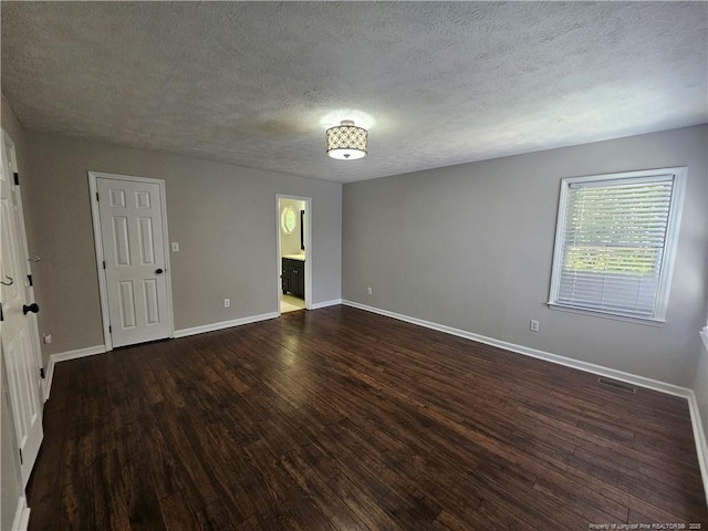5472 Robmont Dr, Fayetteville, NC 28306 - empty room featuring a textured ceiling, baseboards, dark wood-style floors, and visible vents