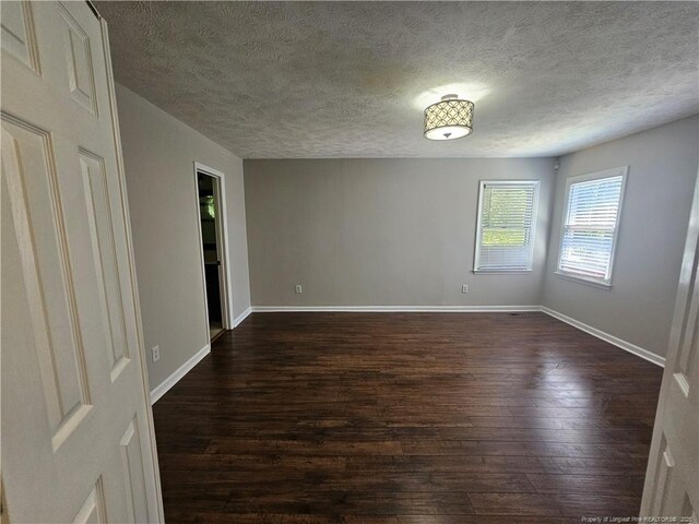 5472 Robmont Dr, Fayetteville, NC 28306 - spare room with a textured ceiling, dark wood-style flooring, and baseboards