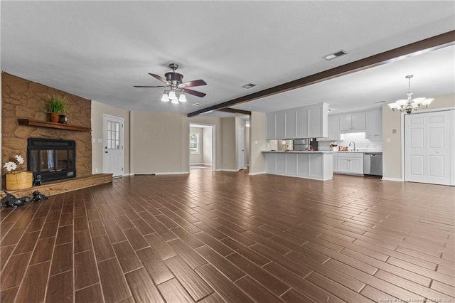 6750 Weeping Water Run, Fayetteville, NC 28314 - unfurnished living room with ceiling fan with notable chandelier, a sink, a fireplace, baseboards, and dark wood-style flooring