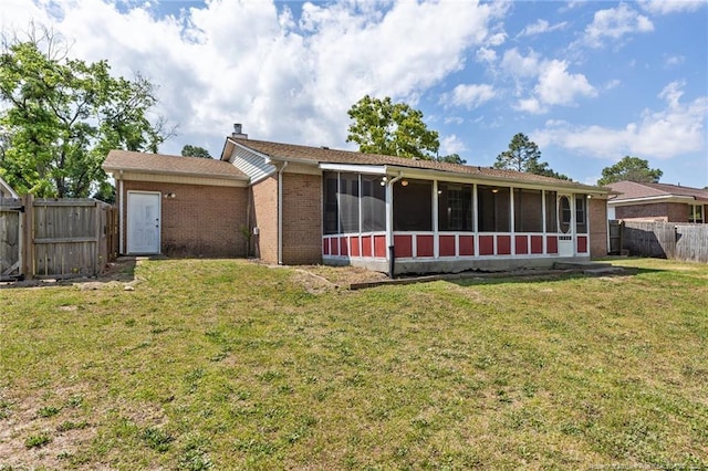 6750 Weeping Water Run, Fayetteville, NC 28314 - back of house featuring a fenced backyard, a sunroom, a chimney, and a lawn