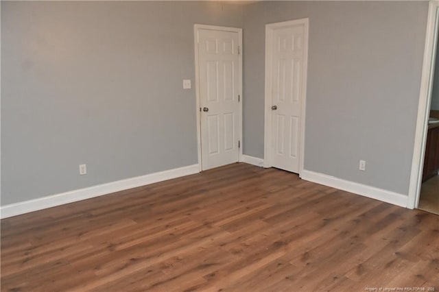 unfurnished bedroom featuring wood finished floors and baseboards