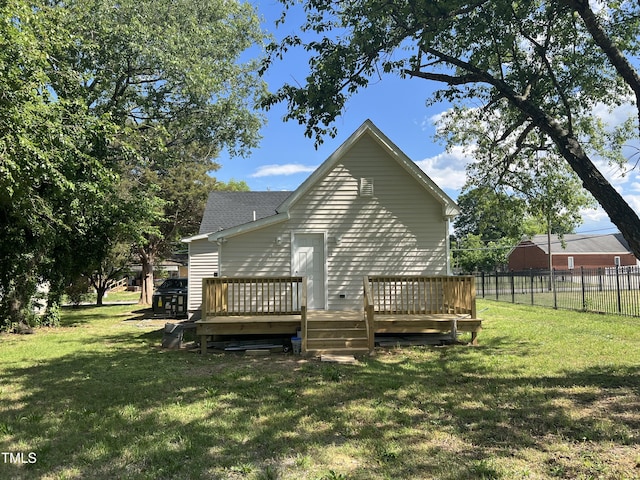 back of house featuring a wooden deck and roof with shingles