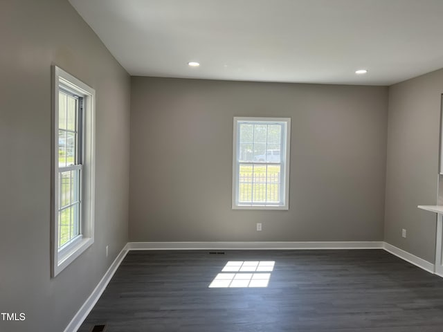 spare room with dark wood-style floors, baseboards, and recessed lighting