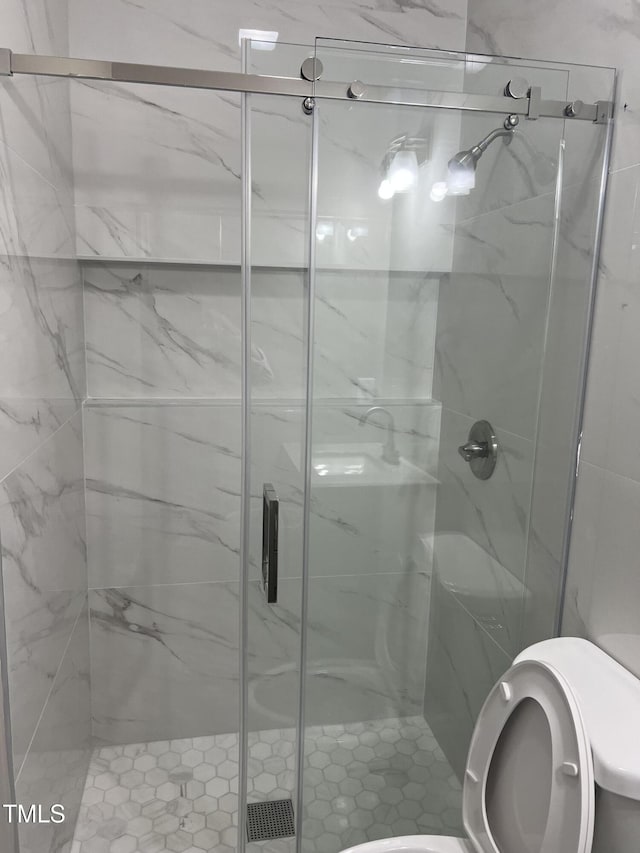 full bathroom featuring toilet and a shower stall
