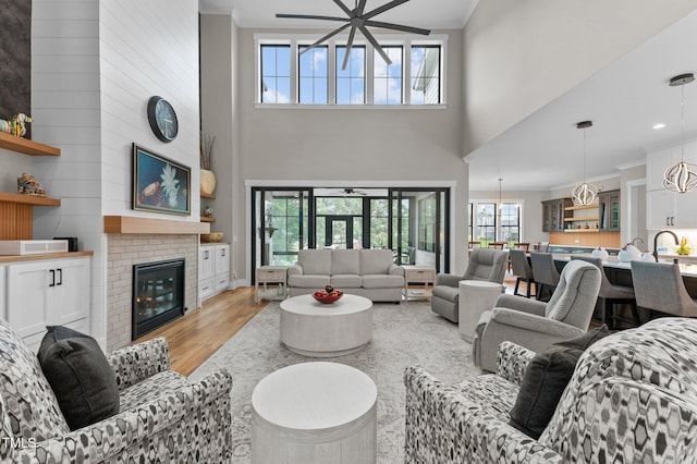 1229 Perry Bluff Dr, Wake Forest, NC 27587 - living area with a towering ceiling, ornamental molding, a fireplace, light wood finished floors, and recessed lighting
