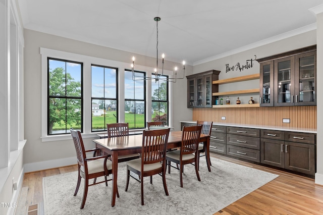 1229 Perry Bluff Dr, Wake Forest, NC 27587 - dining room featuring a chandelier, light wood-type flooring, crown molding, and baseboards