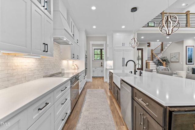 1229 Perry Bluff Dr, Wake Forest, NC 27587 - kitchen featuring a sink, premium range hood, premium appliances, light wood-type flooring, and white cabinetry