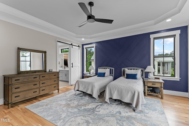 1229 Perry Bluff Dr, Wake Forest, NC 27587 - bedroom with a barn door, a tray ceiling, light wood finished floors, recessed lighting, and baseboards