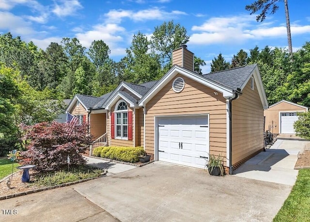 ranch-style home with a chimney, concrete driveway, an attached garage, and a shingled roof