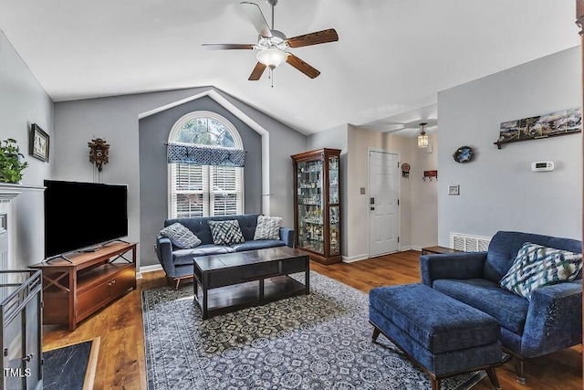 living room with ceiling fan, wood finished floors, lofted ceiling, and baseboards