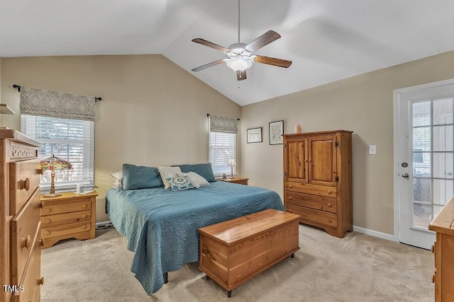 bedroom with multiple windows, light colored carpet, vaulted ceiling, and a ceiling fan