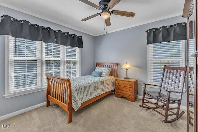 carpeted bedroom featuring baseboards, crown molding, and ceiling fan