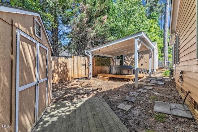 fenced backyard featuring a hot tub and a wooden deck