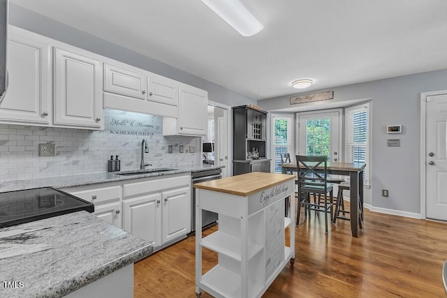 kitchen featuring dishwasher, open shelves, wood counters, a sink, and white cabinets