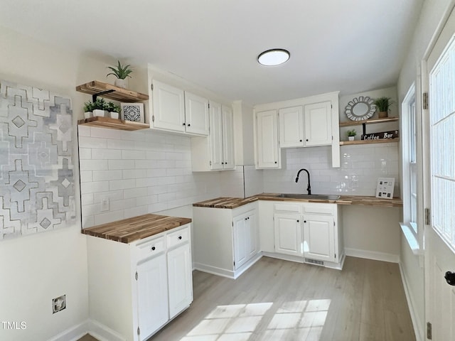116 Lumpkin St, Raleigh, NC 27610 - kitchen featuring open shelves, a sink, tasteful backsplash, and light wood finished floors