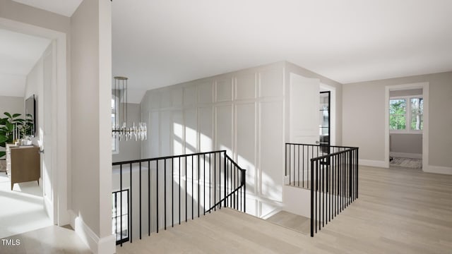 stairs featuring a chandelier, wood finished floors, and baseboards