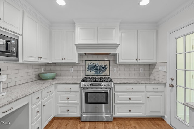4830 N Hls, Raleigh, NC 27612 - kitchen featuring stainless steel gas range oven, white cabinets, plenty of natural light, ornamental molding, and recessed lighting
