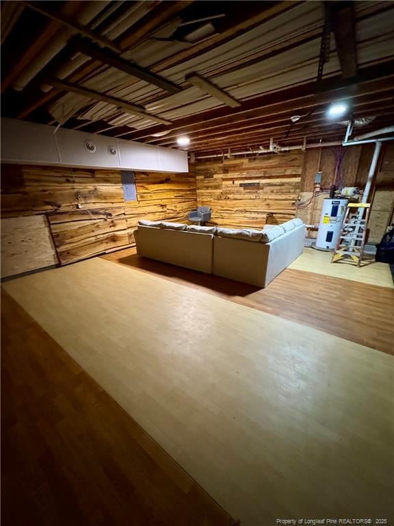 interior space featuring water heater, wood walls, and wood finished floors