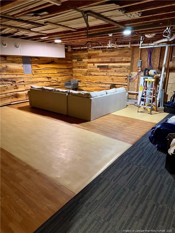 unfinished basement with wood walls and wood finished floors