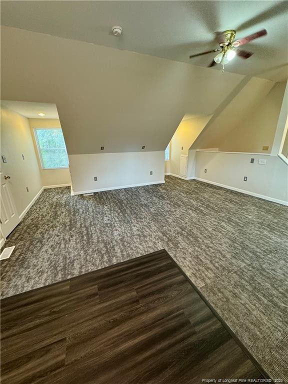 additional living space with vaulted ceiling, ceiling fan, carpet flooring, and baseboards