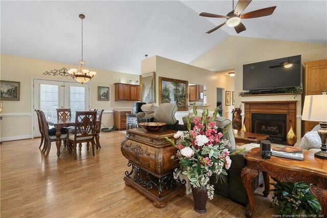 5201 Flynn Dr, Lumberton, NC 28360 - living area with vaulted ceiling, a ceiling fan, a fireplace, a chandelier, and light wood finished floors