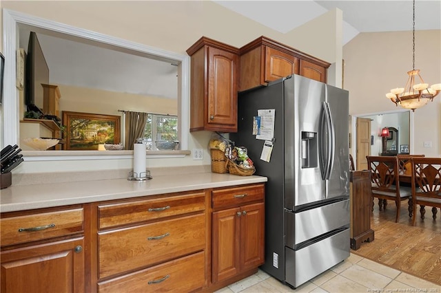 5201 Flynn Dr, Lumberton, NC 28360 - kitchen featuring stainless steel fridge, brown cabinetry, a chandelier, light countertops, and light tile patterned flooring