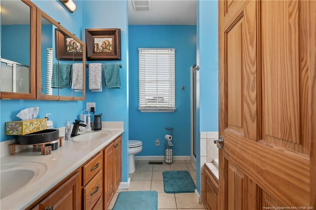 5201 Flynn Dr, Lumberton, NC 28360 - bathroom featuring tile patterned floors, a stall shower, toilet, double vanity, and baseboards