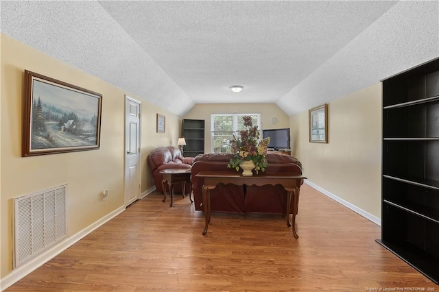 5201 Flynn Dr, Lumberton, NC 28360 - living room with a textured ceiling, light wood finished floors, lofted ceiling, and baseboards