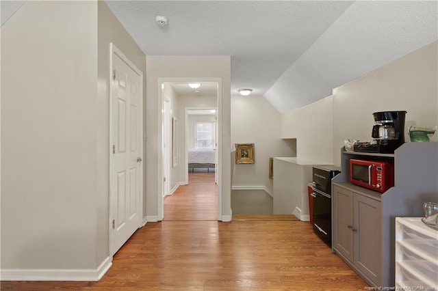 5201 Flynn Dr, Lumberton, NC 28360 - hall featuring light wood-style floors, vaulted ceiling, and baseboards
