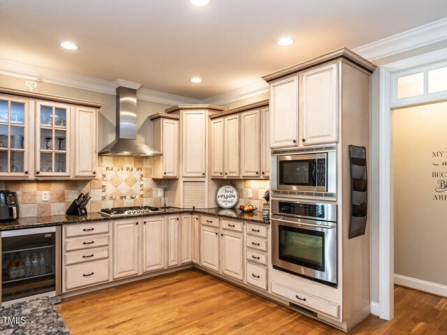 91 E Walker Woods Ln, Clayton, NC 27527 - kitchen with stainless steel appliances, wall chimney range hood, beverage cooler, crown molding, and decorative backsplash